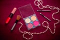 Makeup cosmetic kit Ã¢â¬â eye shadows, highlighter, lip gloss and blush, brushes and pink string of pearls Royalty Free Stock Photo